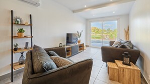 A modern living room with a sofa, a TV, and a wooden coffee table.