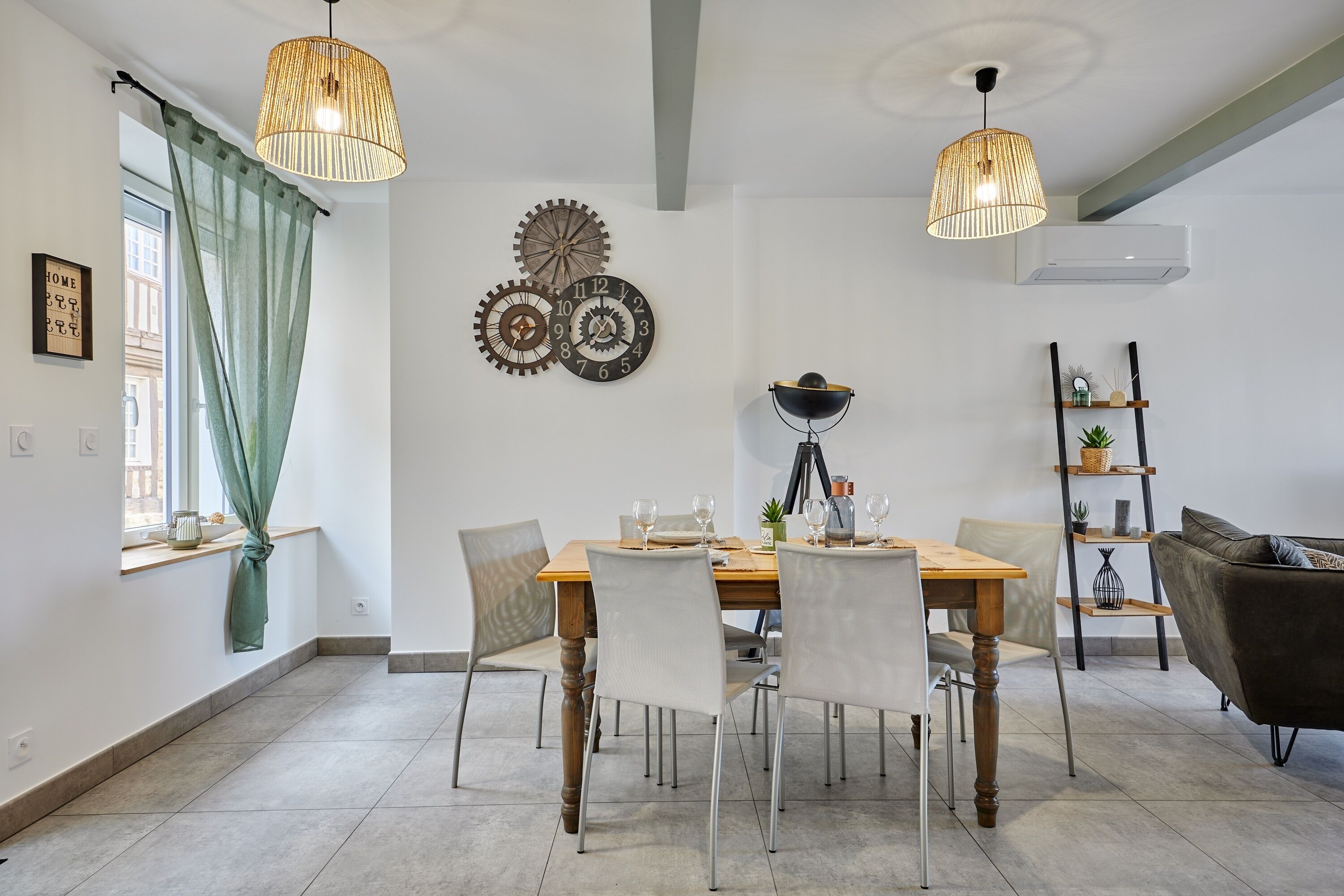 Un coin repas avec une table en bois, des chaises et un lustre.