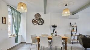 A dining area with a wooden table, chairs, and a chandelier.