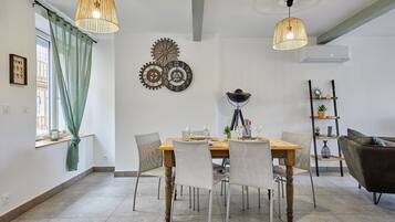 Un coin repas avec une table en bois, des chaises et un lustre.