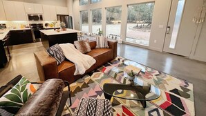 A spacious living area with a sofa, coffee table, and a view of the outside. - Stunning 'Ranch Modern' + Stars! + Firepit! (Driftwood)