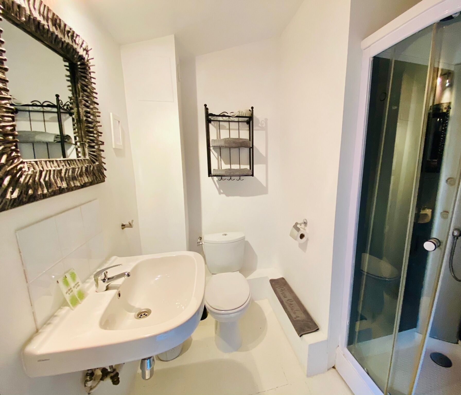A bathroom with a white sink, toilet, and shower.