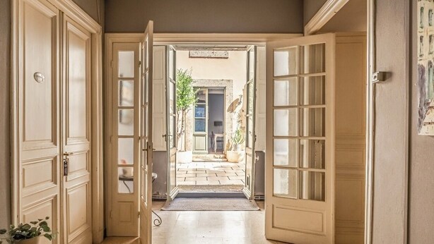 An open hallway with double doors leading to a courtyard. - Logement Touristique Villa Eugénie (Lezignan-Corbieres)
