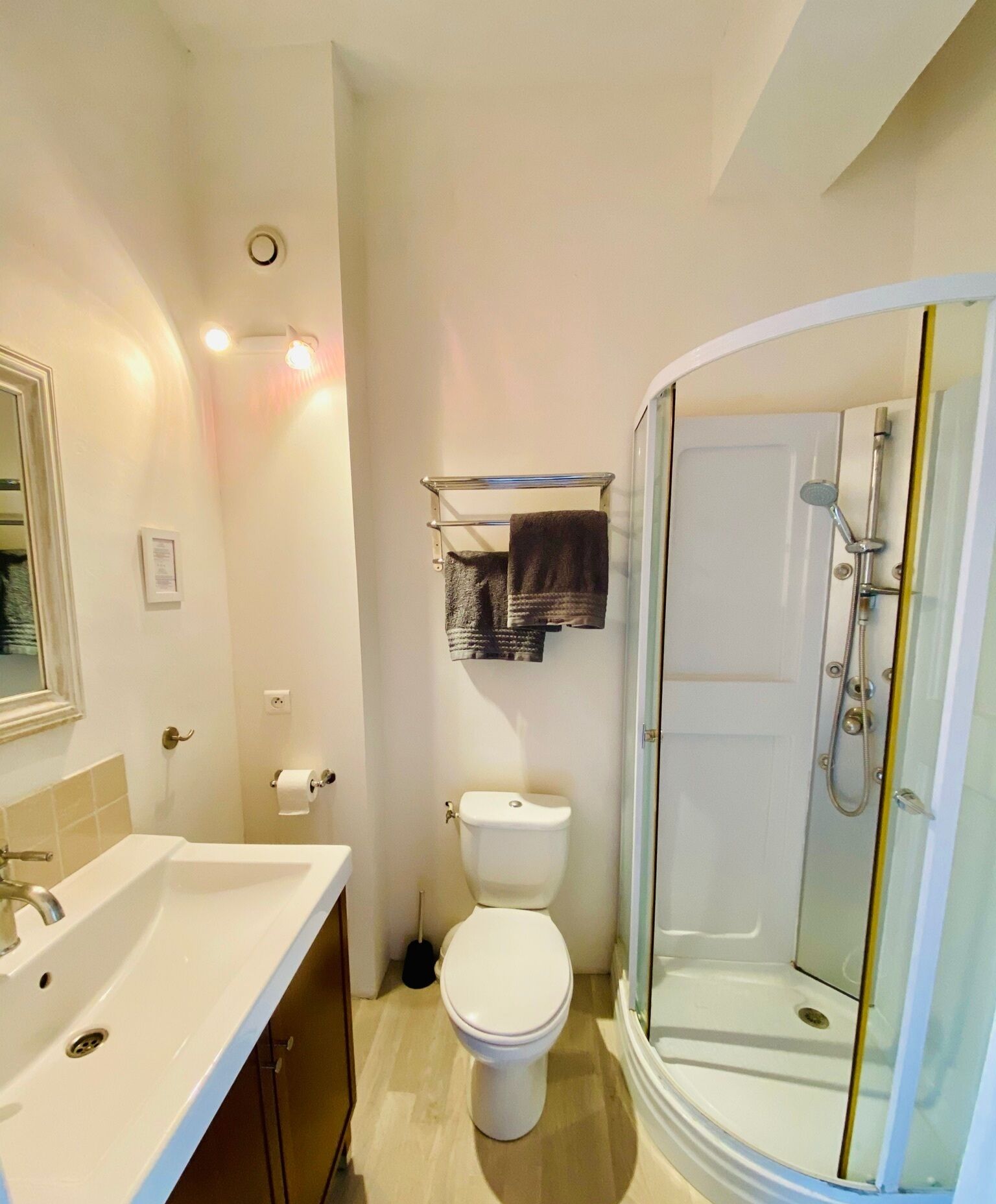 A bathroom with a white sink, toilet, and a glass-enclosed shower.