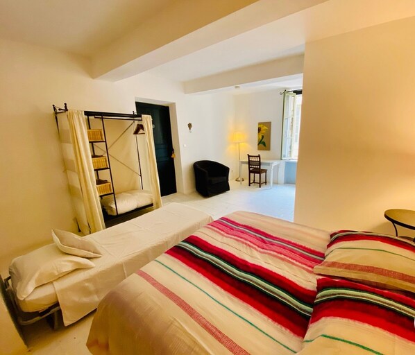 A bedroom with a bed, a chair, a desk, and a wardrobe. - Logement Touristique Villa Eugénie (Lezignan-Corbieres)