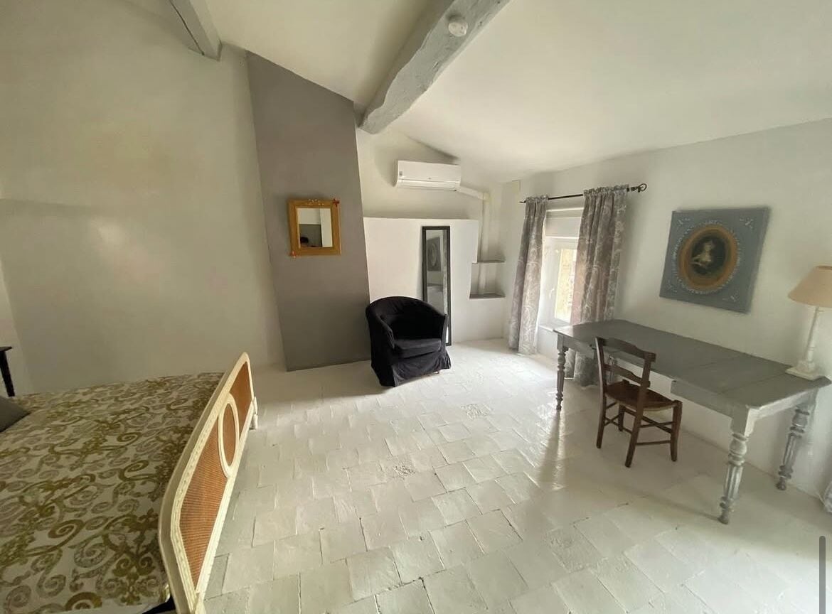 A bedroom with a bed, a desk, and a chair.