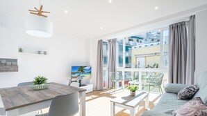 A modern living room with a dining area, large windows, and a balcony with outdoor furniture. - Alameda 16-3 Apartment Beach-Old Town (Benidorm)