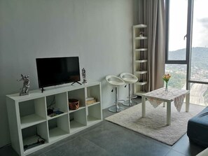 Relax in this stylish living room with a flat-screen TV and city views.