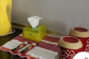 A simple, functional space with a patterned cloth and decorative drums.