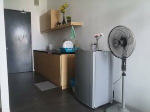 Compact kitchen with a refrigerator, oven, and microwave, offering a convenient space for meal preparation.