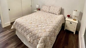 Ein Schlafzimmer mit Bett, Nachttisch, Klimaanlage und Deckenleuchte.