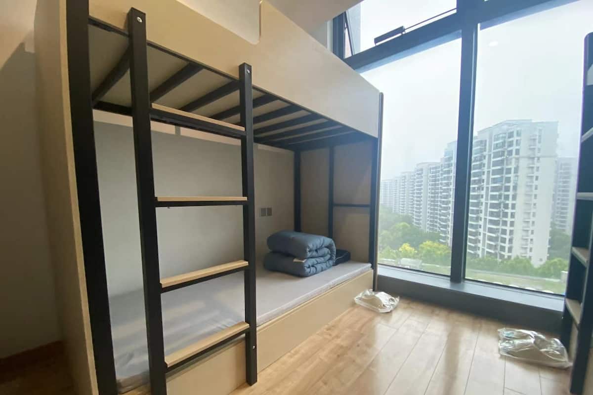 A bunk bed room with a view of high-rise buildings.