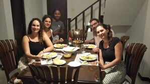 A group of people dining at a table with various dishes.