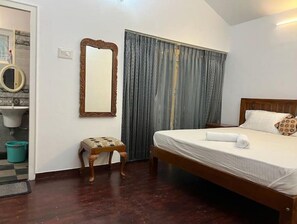 Relax in a cozy space with a comfortable bed, a nightstand, and a large mirror.