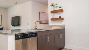 A modern kitchen with stainless steel appliances, dark wooden cabinets, and granite countertops.