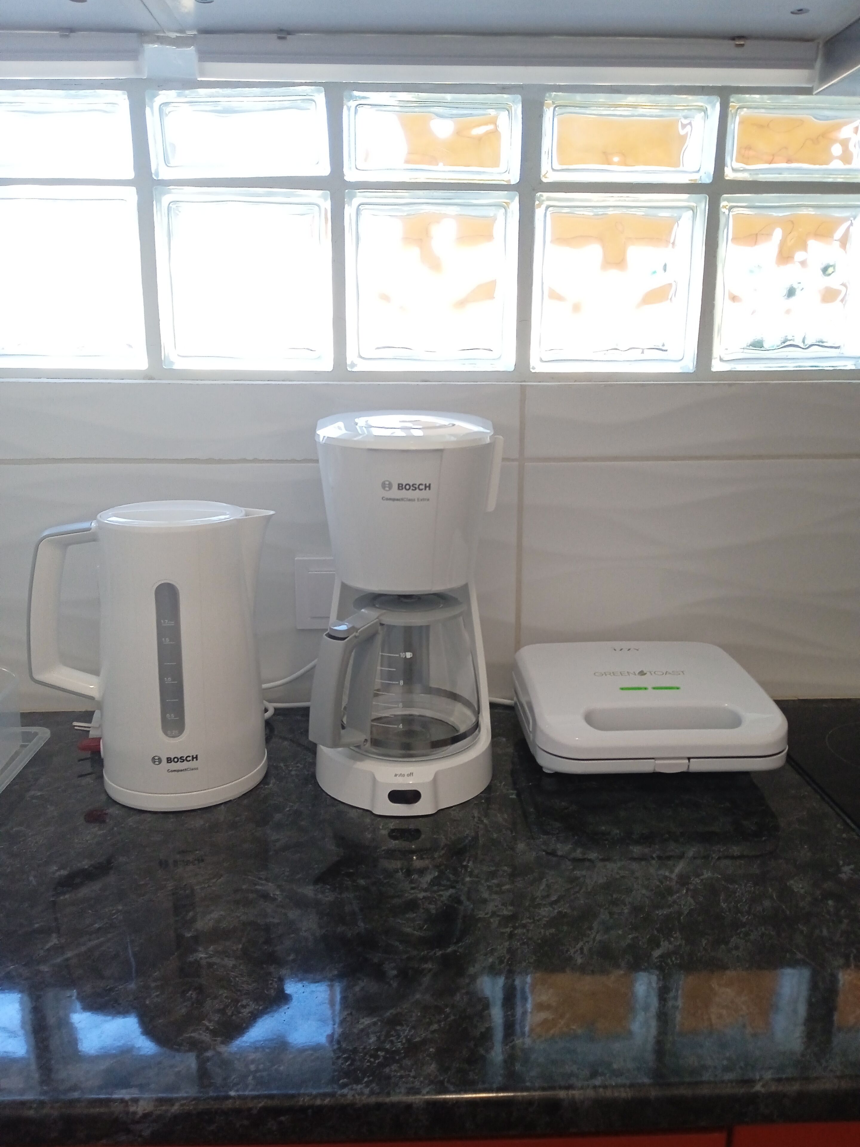 A kitchen with a Bosch coffee maker, a Bosch electric kettle, and a toaster on the counter.