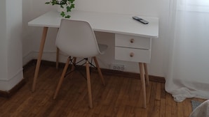 A white desk with a chair, a small plant, and a remote control. - Acropolis penthouse with breathtaking city view (Athina)