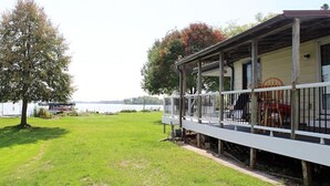 A lakeside cabin with a covered porch and a view of the lake. - Entire 3 Bedroom Lake House in Beaver Dam (Beaver Dam)