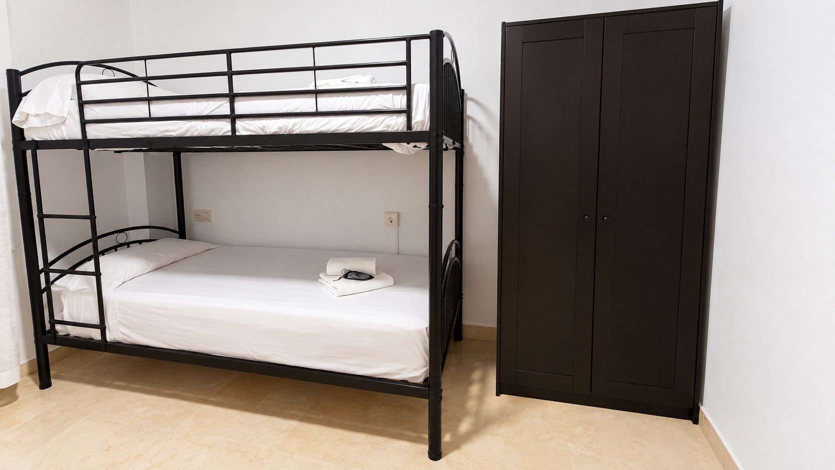 Uma cama de solteiro com um guarda-roupa ao lado.