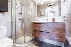 Une salle de bain moderne avec une douche à parois de verre, un meuble-lavabo en bois et un grand miroir.