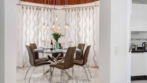 Een moderne eetruimte met een glazen tafel, vier bruine stoelen en een decoratief middelpunt.