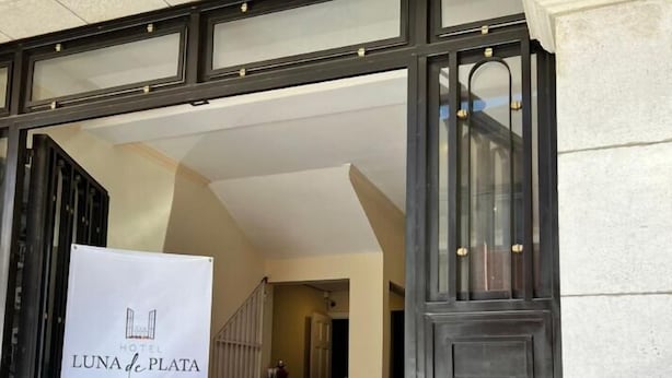A hotel entrance with a sign for Luna de Plata, a stone wall, and a tiled floor. - Luna de Plata (Quetzaltenango)