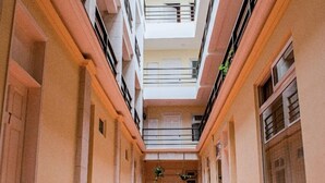 A multi-level interior with a central atrium, balconies, and a tiled floor. - Luna de Plata (Quetzaltenango)