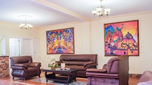 A living room with brown leather sofas, a coffee table, and two paintings on the wall. - Luna de Plata (Quetzaltenango)