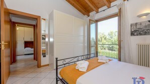 Ein Hotelzimmer mit Bett, Kleiderschrank, Bad und einem Balkon mit Blick.