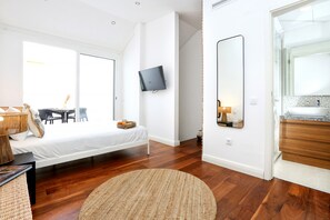 A modern bedroom with a bed, bedside table, and a mounted TV.