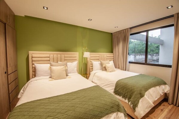 2 dormitorios, caja fuerte, escritorio y tabla de planchar con plancha