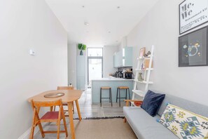 Un appartement moderne comprenant un coin repas, une cuisine et un salon.