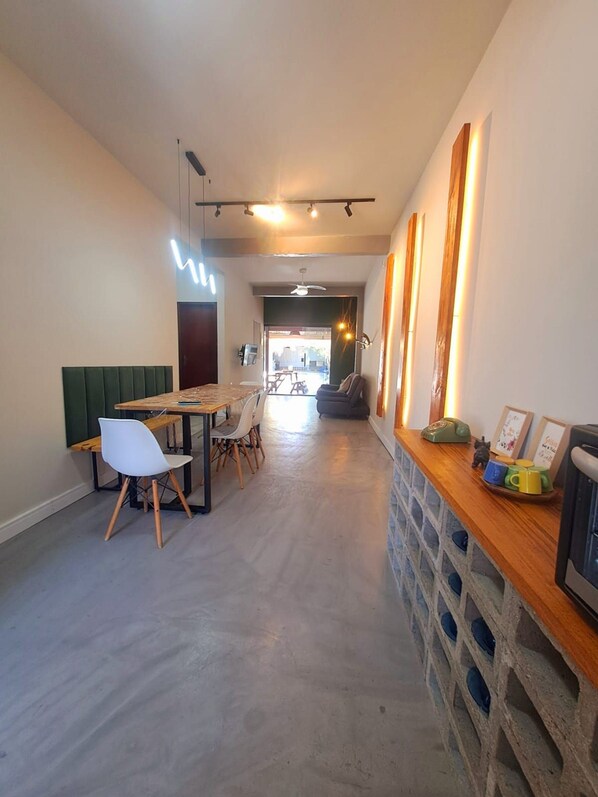 A modern interior with a dining area, a sofa, and a long counter with decorative items.