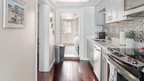 A modern kitchen with white cabinets, a stainless steel range, and a patterned backsplash. - Pet-Friendly 1855 Garden Retreat • Savannah (Savannah)