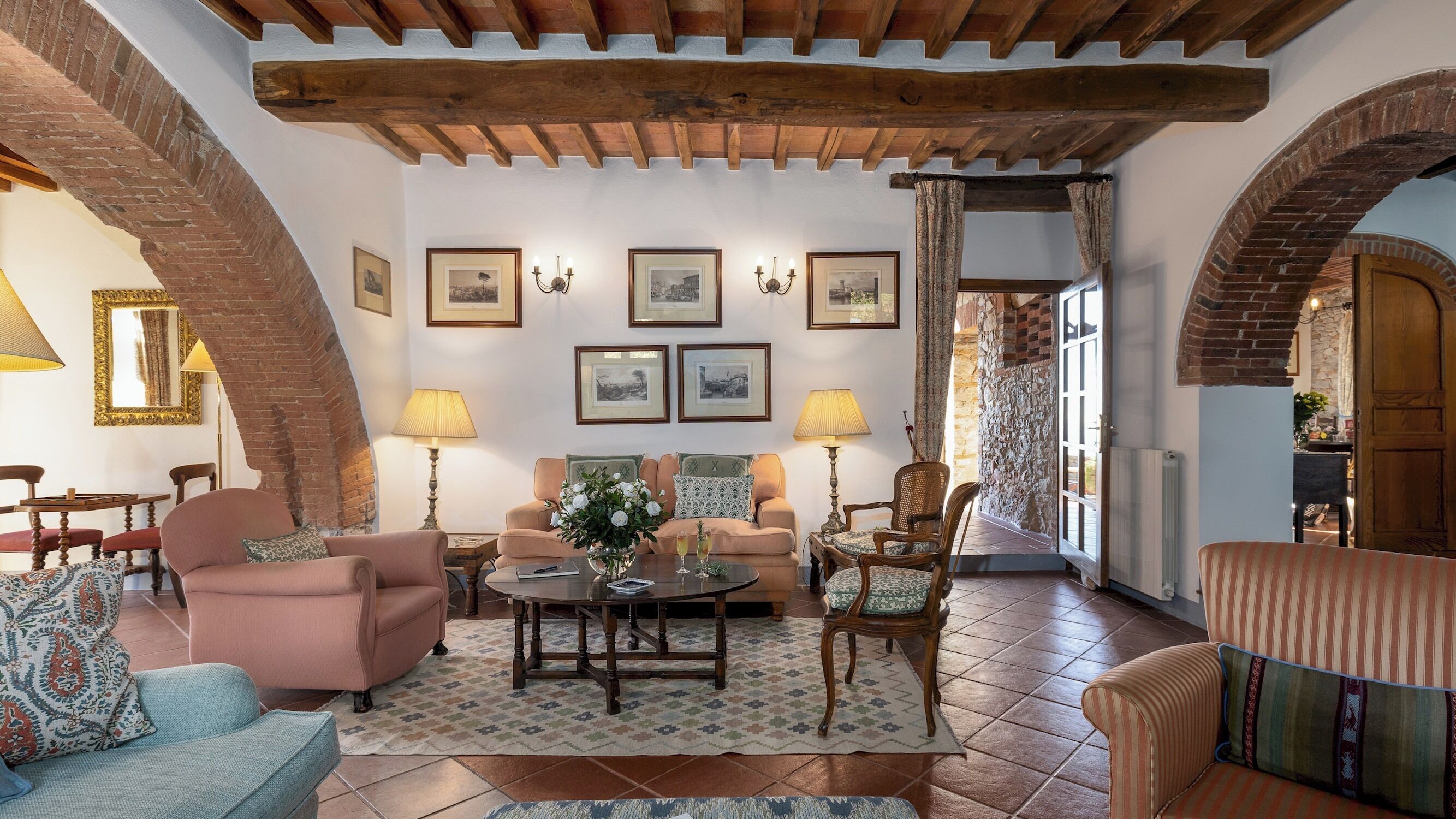 A cozy living room with a fireplace, comfortable seating, and framed artwork on the walls.