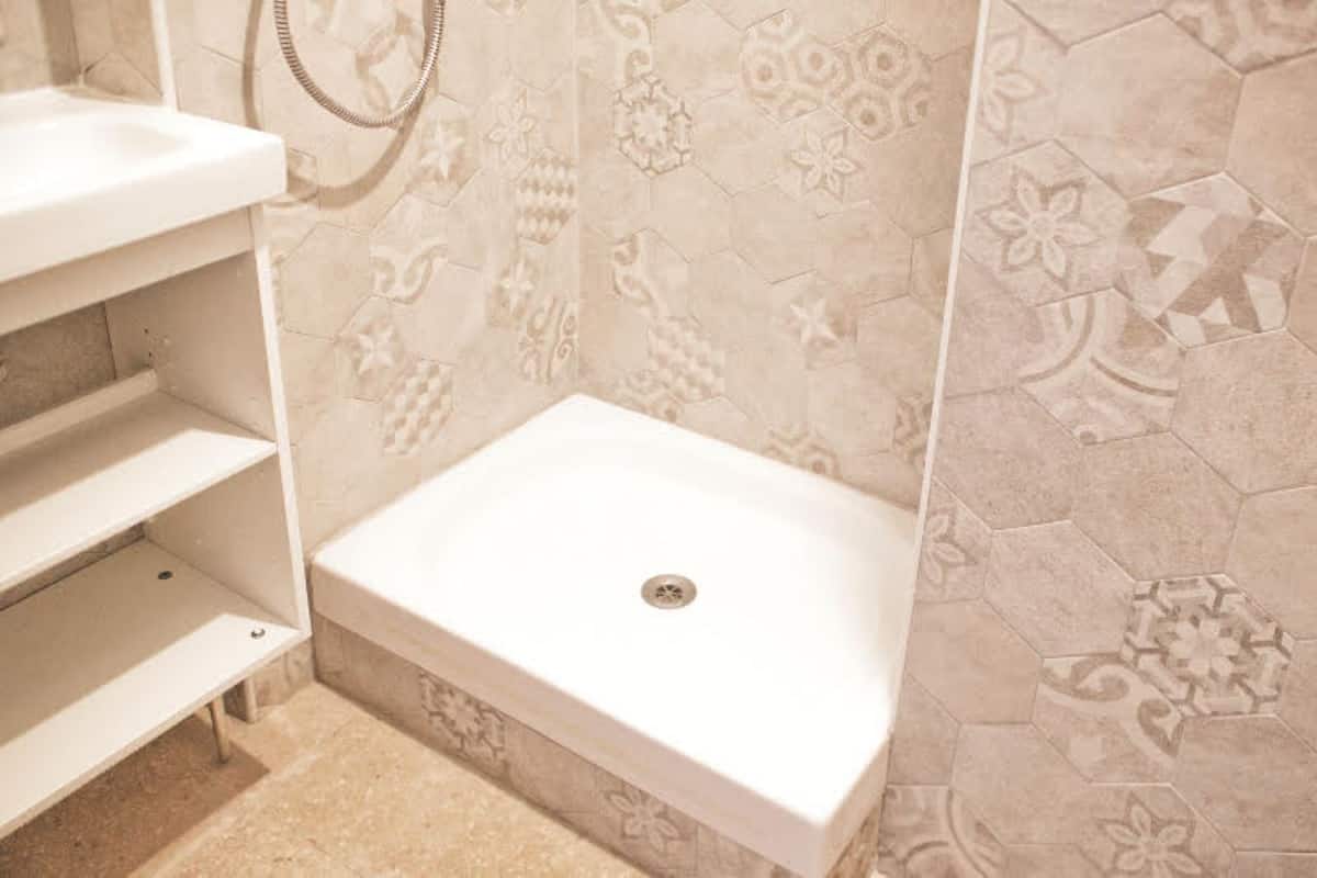 A bathroom with a shower area, a sink, and a toilet.
