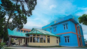 A building with a blue and orange facade, a green-roofed structure, and a sign indicating 'Hotel Stulikang'. - Hotel O Sidikalang Near KEJAKSAAN NEGERI DAIRI (Kota Sidikalang)