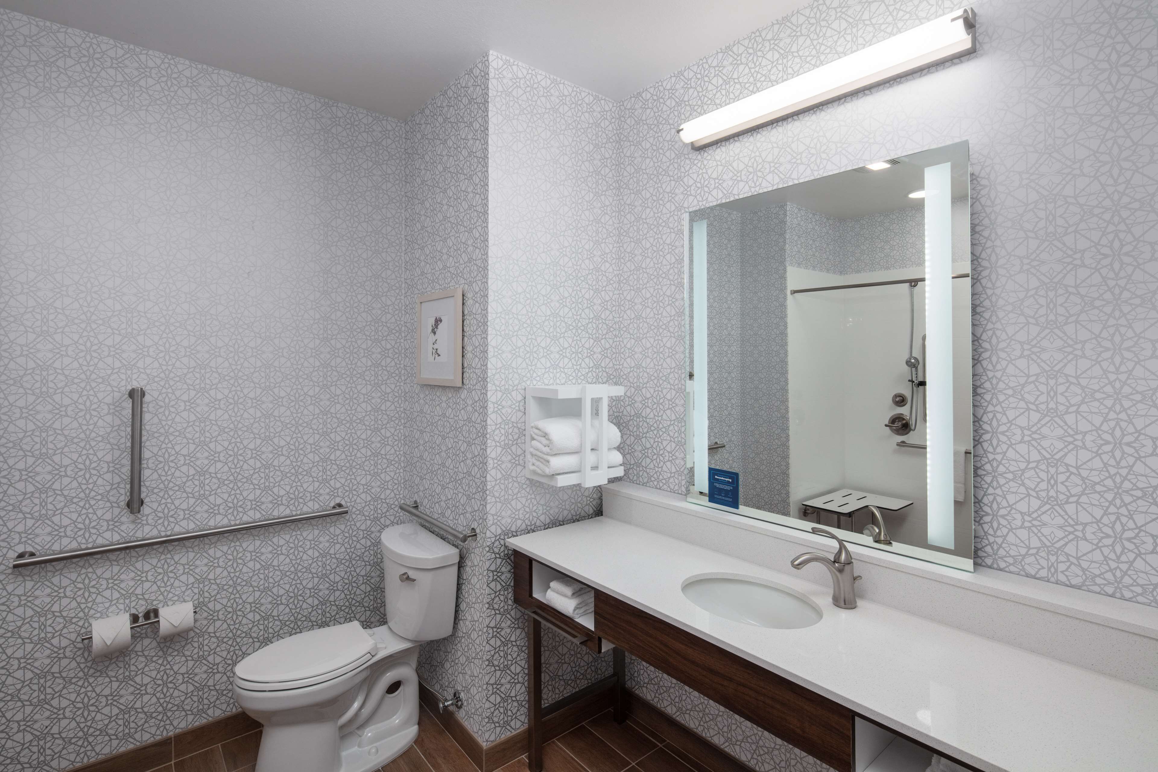 A modern bathroom with a toilet, sink, and shower.