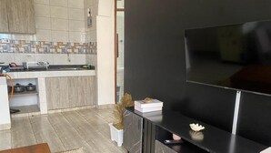 A modern kitchen with a tiled backsplash, a built-in oven, and a sink. - Aval Homes-Modern 1 bedroom apartment in Bamburi (Mombasa)