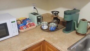 Une cuisine équipée d’un four à micro-ondes, d’un grille-pain, d’une machine à café et de diverses collations.