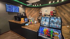 A coffee shop counter with a menu board, a cash register, a coffee machine, and a refrigerated display case with various beverages. - Walk In luxury condo with pools and hot tub! Comfy beds! (Branson)