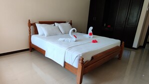 A neatly made bed with white linens and two swan-shaped decorations. - Peace In Paradise with mountain view and walking distance to the beach (Au Cap)