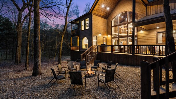 Eine mehrstöckige Holzhütte mit Terrasse und Sitzbereich im Freien.