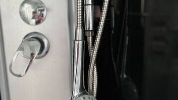 A shower with a flexible hose and a handheld showerhead.