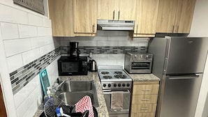 A kitchen with wooden cabinets, a stainless steel refrigerator, a stove, and a microwave. - Located on Paradise Island, Bahamas, close to the Atlantis Resort and beach.  (Nassau)