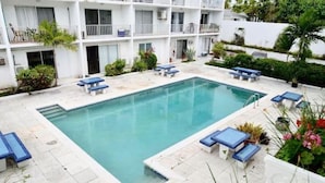 A swimming pool with lounge chairs and a building with balconies in the background. - Located on Paradise Island, Bahamas, close to the Atlantis Resort and beach.  (Nassau)