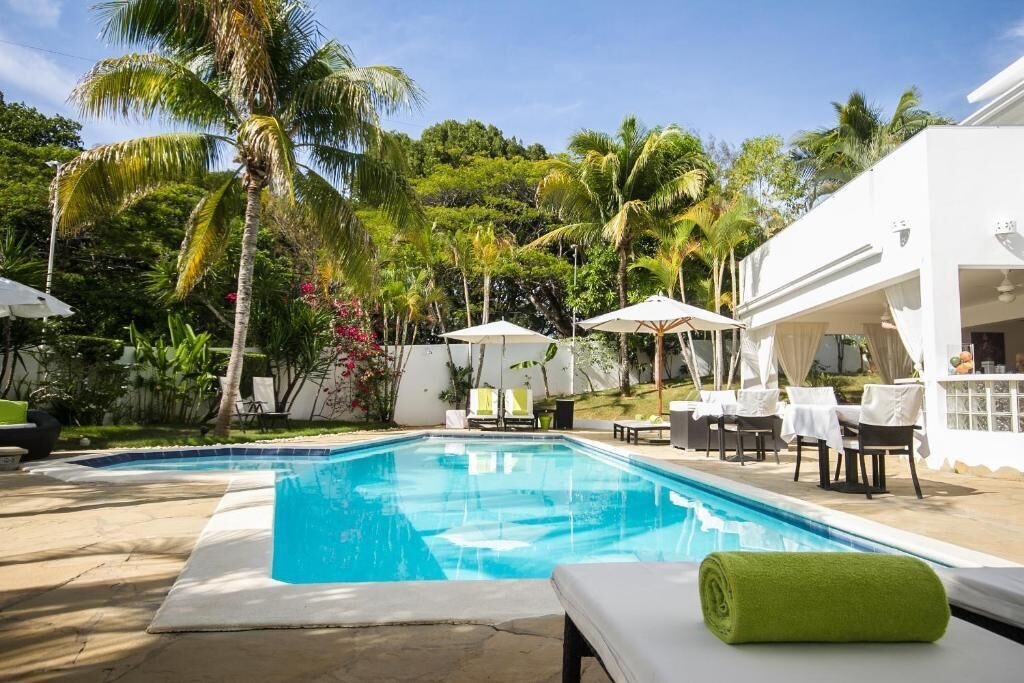 Una piscina al aire libre, sombrillas, tumbonas