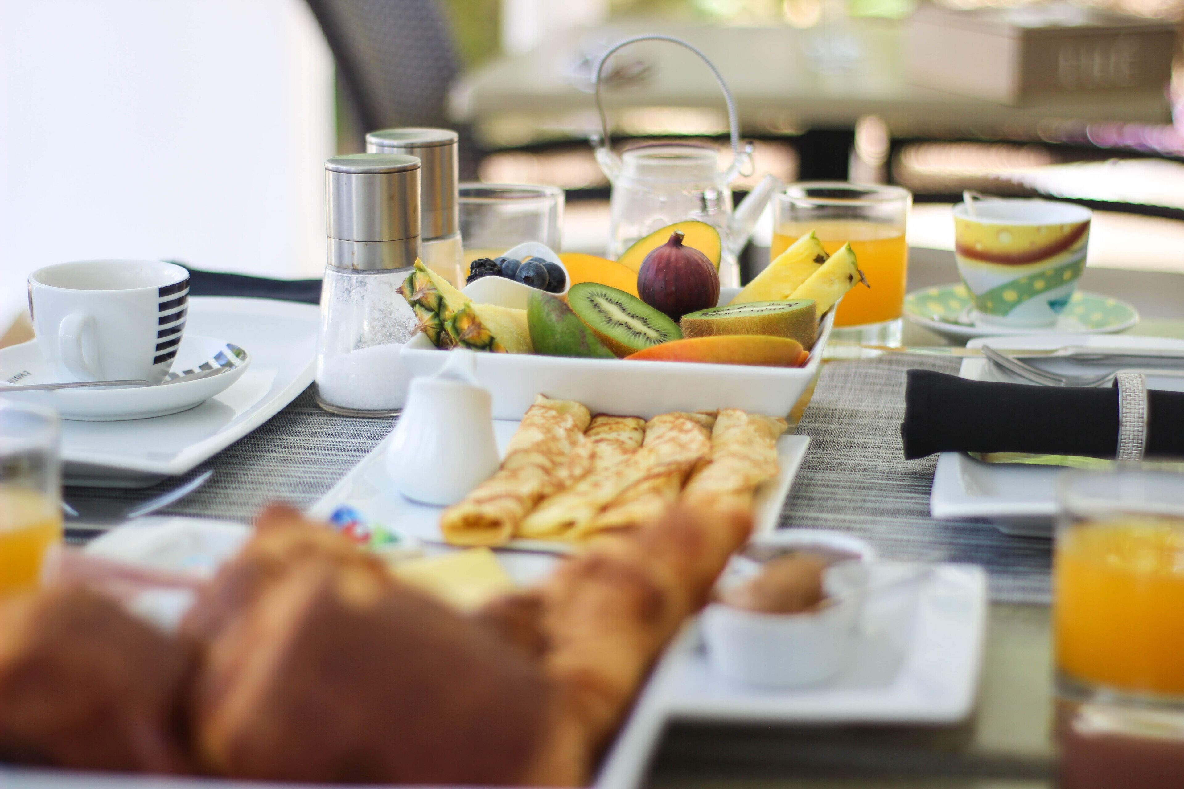 Une table dressée pour le petit-déjeuner, avec différents aliments et boissons.