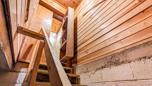 Una escalera de madera con barandilla que sube a un nivel superior.