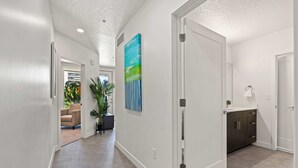 A hallway with a white door, a painting, and a plant. - Luxury Apartment in Salt Lake City (Salt Lake City)